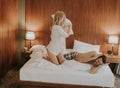 Playful young couple having pillow fight on bed in room Royalty Free Stock Photo