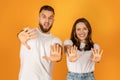 Playful young couple with surprised expressions showing their palms to the camera Royalty Free Stock Photo