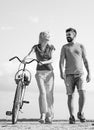 Playful young man with his beautiful girlfriend on the love way. Summer woman with retro bike on blue sky background Royalty Free Stock Photo