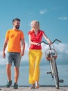 Playful young man with his beautiful girlfriend on the love way. Summer woman with retro bike on blue sky background Royalty Free Stock Photo