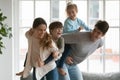 Young parents playing with energetic children at home.