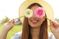 Playful young woman covering her eyes with fresh colorful flowers. Enjoying spring time outdoor Royalty Free Stock Photo