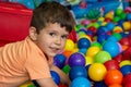 Playground with ball pit indoor. Joyful kid having fun at indoor kids ball zone. Royalty Free Stock Photo