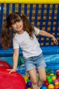 Playground with ball pit indoor. Joyful kid having fun at indoor play center. Child playing with colorful balls in playground ball Royalty Free Stock Photo