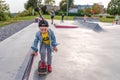 Playground children play skate, little boy 3-5 years old, learning skate, scooter board skateboard, handrail. In summer Royalty Free Stock Photo