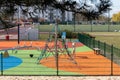 A playground for children to play. Colorful play sets and a safe surface. Coniferous tree branch with cones. Pine.