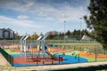 A playground for children to play. Colorful play sets and a safe surface. Coniferous tree branch with cones. Pine.