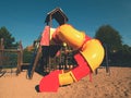 Playground colorful tube slide in public park. New slider tube and wooden ladders Royalty Free Stock Photo