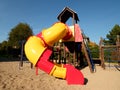 Playground colorful tube slide in public park. New slider tube and wooden ladders Royalty Free Stock Photo