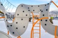 Playground with curvy climber against snow and sky