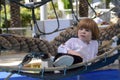 Playground. Grid for games. Rope park. A little boy sits in a hammock and shows his finger.r. Royalty Free Stock Photo