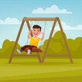 Playground. Happy boy swinging on a swing. Royalty Free Stock Photo