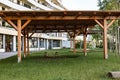 playground in the kindergarten, in the foreground there is a gazebo with a table and benches under a canopy, covered seating area