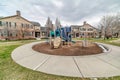 Playground in the neighborhood park surorunded by houses and circular pathway Royalty Free Stock Photo