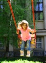 Playground in park. childhood daydream .teen freedom. Happy laughing child girl on swing. Small kid playing in summer Royalty Free Stock Photo