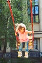 Playground in park. Small kid playing in summer. childhood daydream .teen freedom. Happy laughing child girl on swing Royalty Free Stock Photo