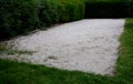 Petanque playground made of white sand in the park among the bushes game with metal balls