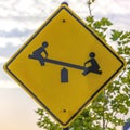 Playground sign with image of children on seesaw