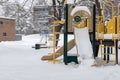 Playground with slide in park without children, covered with snow in winter season Royalty Free Stock Photo