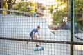 Playground with slides behind a mesh fence. Boys ride skateboards and scooters, blurred background Royalty Free Stock Photo