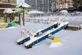 Playground in the snow, swings with a horse covered in snow, unexpected large amounts of snow