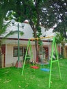 Playground with swings and a lamp post in front of a building Royalty Free Stock Photo