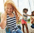 The playground is where we have the most fun together. Portrait of a young girl playing on a swing at the park with her Royalty Free Stock Photo