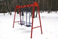 Playground in the winter. Children`s playground in the snow. Children`s swing Royalty Free Stock Photo