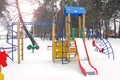 Playground in the winter. Children`s playground in the snow. Children`s swing Royalty Free Stock Photo