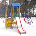 Playground in the winter. Children`s playground in the snow. Children`s swing Royalty Free Stock Photo