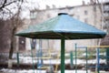 Kindergarten in winter. Old umbrella, stairs for children game. Background apartment house on a cloudy day