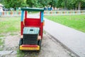 On the playground, a wooden multi-colored train. Near the alley, growing green grass Royalty Free Stock Photo