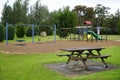 playground with wooden park bench in the forground