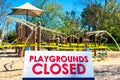 Playgrounds closed sign with blurred outdoor children playground Royalty Free Stock Photo