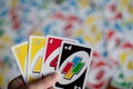 Playing american card game Uno, holding game cards in female hand.