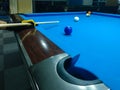 Playing billiard - A shot of a man playing billiard on a blue pool table Royalty Free Stock Photo