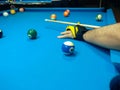 Playing billiard, A shot of a man playing billiard on a blue pool table Royalty Free Stock Photo