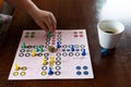 Playing board ludo and coffee with girl's hand Royalty Free Stock Photo