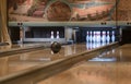 Playing bowling in sports centre. Bowling ball rolling to knock down pins. Bowling ball on the track. Bowler throws a ball on a