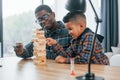 Playing bricks game. African american father with his young son at home