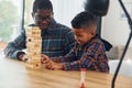 Playing bricks game. African american father with his young son at home