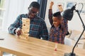 Playing bricks game. African american father with his young son at home