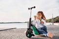 Playing with bubbles. Cute little girl with scooter is outdoors in summertime Royalty Free Stock Photo