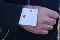 playing card ace of hearts in blue sleeve clothing on the cheaters hand