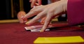 Hands of a young caucasian man playing poker in a casino. Close-up of hands playing poker with chips on red table. Royalty Free Stock Photo