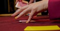 Hands of a young caucasian man playing poker in a casino. Close-up of hands playing poker with chips on red table. Royalty Free Stock Photo