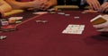 Cards and chips on the table in a casino. Close-up of hands.. Close-up of hands playing poker with chips on red table. Royalty Free Stock Photo