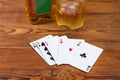 Playing cards combination, bottle and glass whisky on rustic table Royalty Free Stock Photo