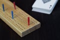 Playing cards and cribbage board on black background