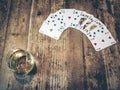 cards and a glas of whiskey on a wooden table. Royalty Free Stock Photo